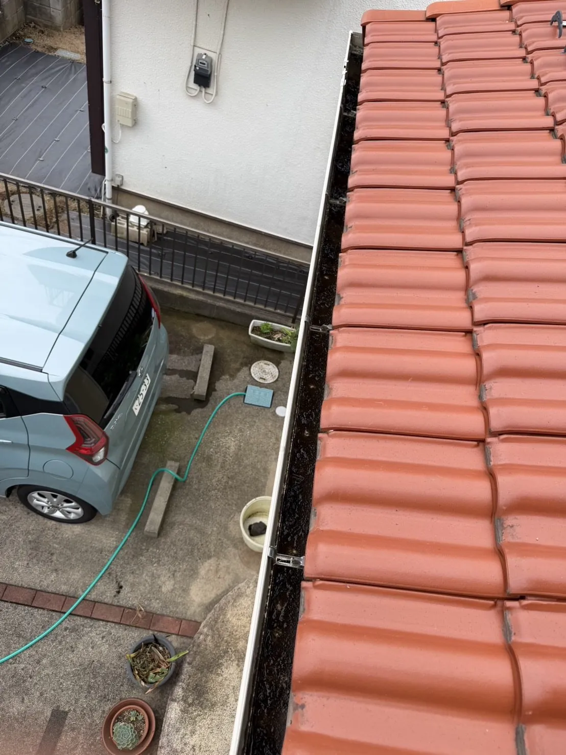 雨樋の底にたまった黒い泥汚れ